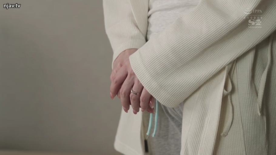 平淡 · 站立 · 面部特写 · 室内房间 · 低头注视 · 白色背心与白色开衫外套 · njav.tv水印