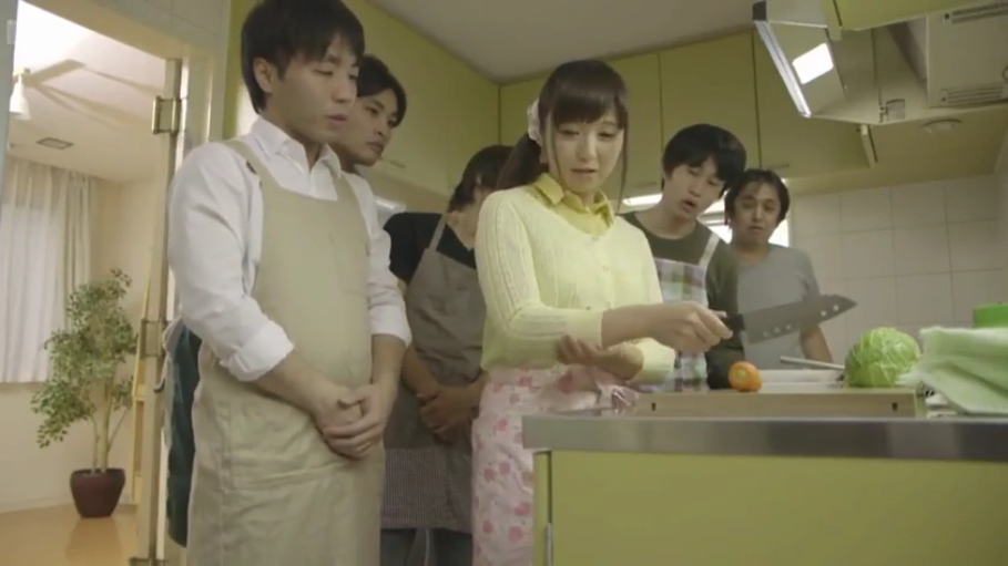略显不安 · 厨房 · 多人场景 · 围裙 · 淡黄色针织开衫 · 女子上半身侧拍