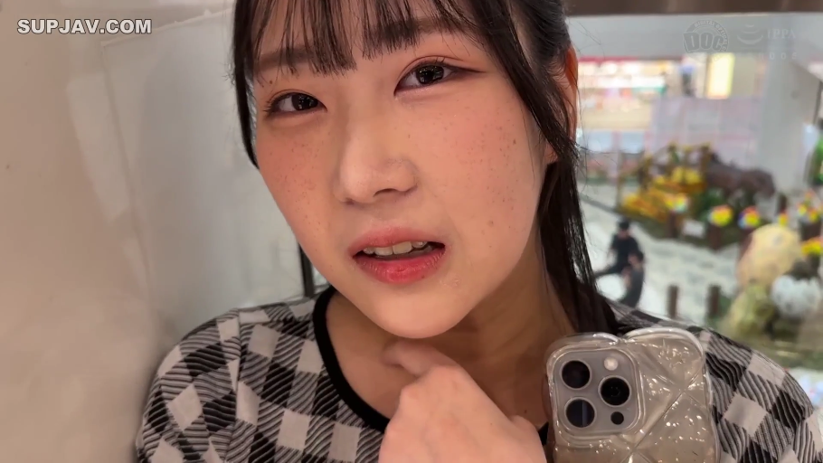 脸部特写 · 智能手机 · 公共区域 · 含羞表情 · 黑白格纹上衣 · 手机壳上有三镜头设计