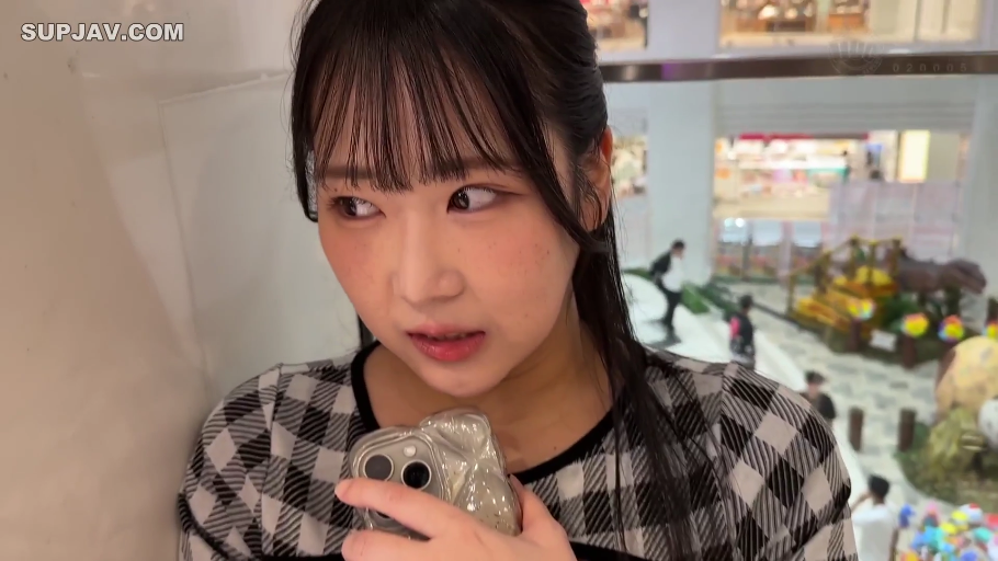 手机特写 · 环顾四周 · 室内公共场所 · 黑白格纹上衣 · 手机壳 · 背景有商场行人走动