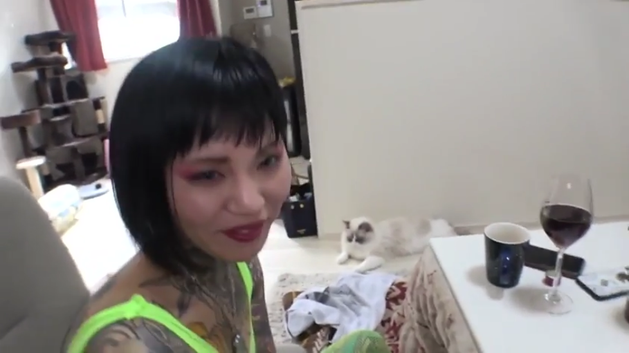 客厅 · 酒杯 · 肩部纹身特写 · 桌上杂物 · 浓妆 · 荧光绿细肩带背心