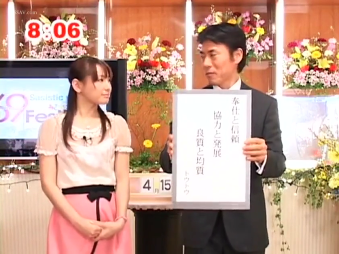 平静 · 电视台演播室 · 标语牌 · 人物半身特写 · 女性穿浅色短袖上衣和粉色短裙 · 时间显示8:06