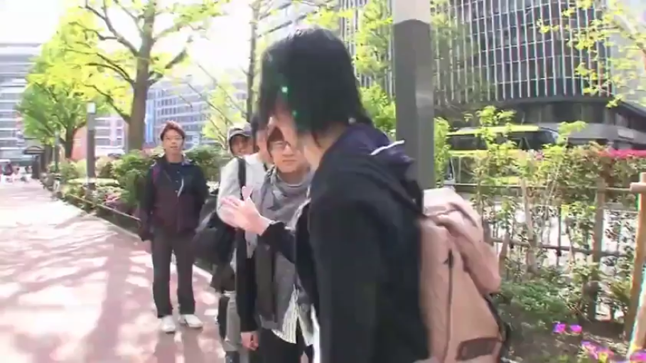 人行道 · 深色连帽衫 · 街拍风格 · 背包 · 自然交流 · 侧面交谈特写