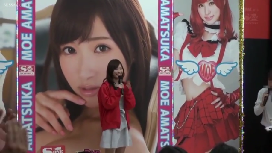 脸部特写 · 站姿 · 微笑 · 麦克风 · 室内舞台 · 红色卫衣外套 · 持麦演讲 · 女优见面会