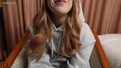 室内 · 坐姿 · 微笑 · 面对镜头 · 椅子 · 灰色连帽卫衣 · 长卷发 · 下半脸