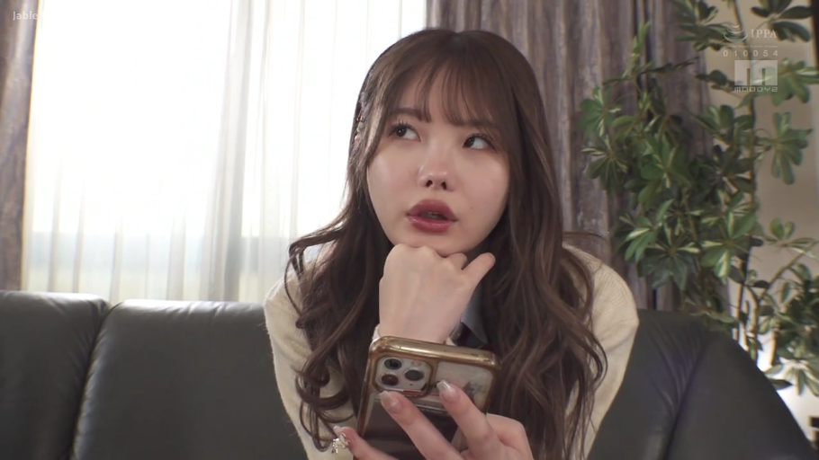 室内 · 坐姿 · 面部特写 · 看手机 · 智能手机 · 开衫 · 长卷发 · 神情迷茫