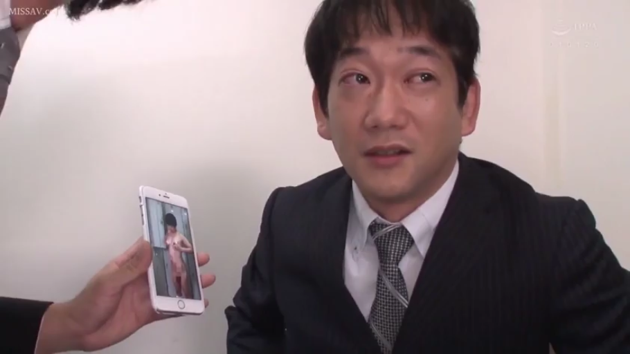室内 · 深色西装 · 不知所措 · 智能手机 · 手机屏幕内容特写 · 照片内容是女性裸体
