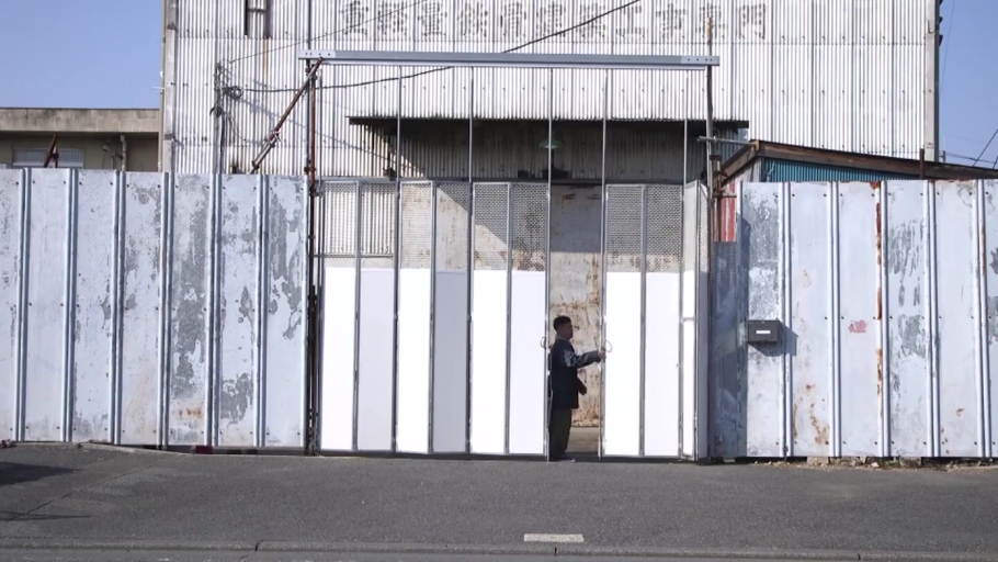 平静 · 建筑工地 · 深色夹克 · 空旷场地 · 建筑大门