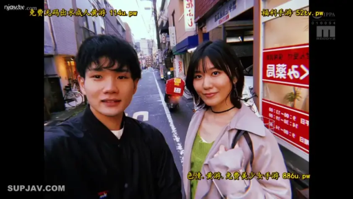 自然 · 日本城市街头 · 手机 · 两人上半身特写 · 女性穿浅色外套内搭绿色上衣 · 背景有日文标识