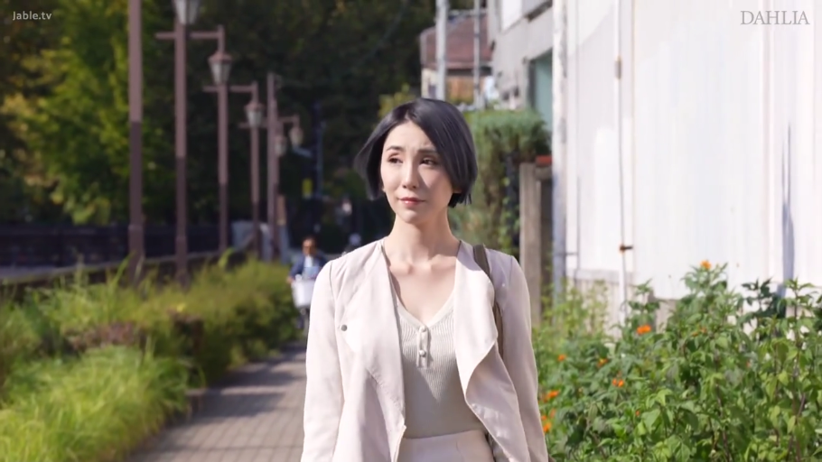略带忧郁 · 上半身特写 · 人行道 · 侧逆光 · ショルダーバッグ · 米白色外套