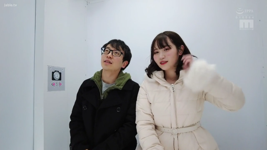 白色密闭空间 · 男子表情木讷 · 女子米白色长款羽绒服