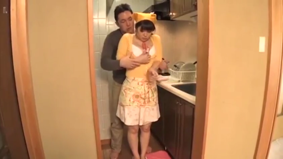 厨房 · 黄色帽子 · 家庭环境 · 抚摸 · 黄色厨师帽 · 女人面露羞涩与困扰 · 男人手部抚摸胸部的特写