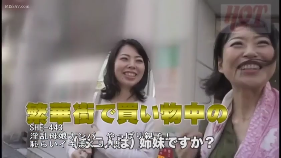 职业化微笑 · 繁华闹市 · 人物面部特写 · 粉色披肩或外套 · 画面包含日语标题字幕