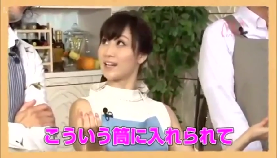 微笑 · 日语字幕 · 围裙 · 室内演播室 · 白色立领无袖上衣 · 女子面部特写