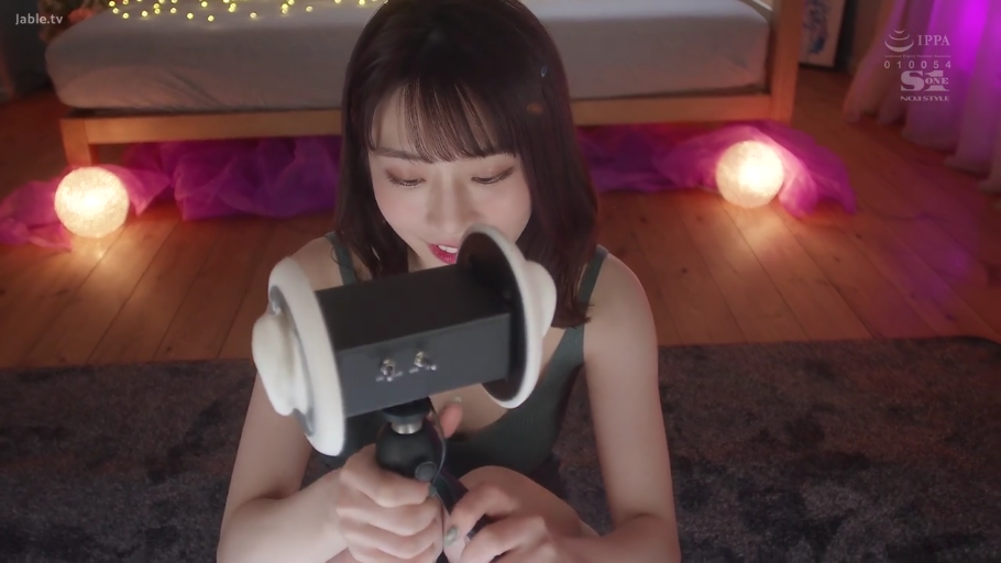 卧室 · 轻微微笑 · 双手持物特写 · 灰色吊带背心 · 背景灯光模糊 · 暖色氛围灯