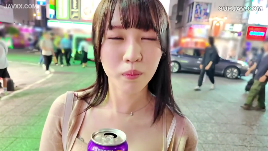 脸部特写 · 微笑 · 浅色针织开衫 · 饮料罐 · 背景有行人 · 夜晚