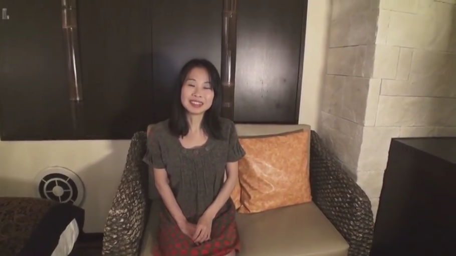 坐姿 · 中景 · 沙发 · 微笑 · 酒店房间 · 面对镜头 · 连衣裙 · 熟女