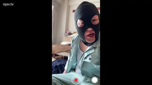 卧室或客厅 · 说话状 · 浅绿色工装外套 · 戴面具男子的面部特写 · 黑色头套面具 · 画面带有拍摄录制按钮UI