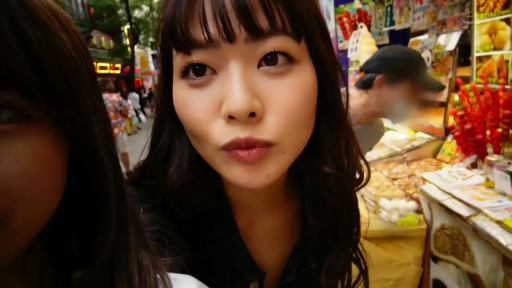 脸部特写 · 专注看着镜头 · 深色上衣 · 自拍视角 · 摄像设备 · 美食街