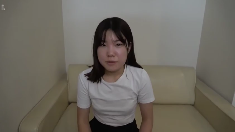坐姿 · 中景 · 平静 · 沙发 · 客厅 · 白色T恤 · 直视镜头 · 采访风格