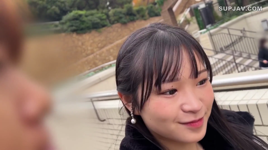 耳坠 · 楼梯旁 · 黑色毛绒外套 · 女性面部特写 · 微笑着注视对方 · 左侧有模糊的人物轮廓