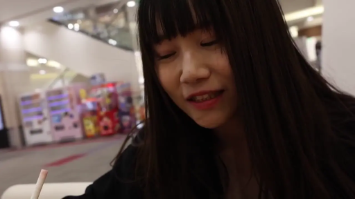 坐姿 · 脸部特写 · 黑色外套 · 生活随拍 · 自然开心 · 室内商场 · 注视微笑 · 背景贩卖机