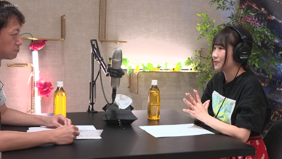 交流中 · 麦克风支架 · 录音室 · 花色半身裙 · 女子侧面脸部特写 · 背景有绿植和装饰灯