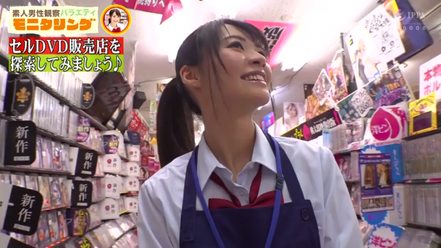 脸部特写 · 微笑 · 深蓝色围裙 · 成人用品店 · 货架上有大量DVD封面