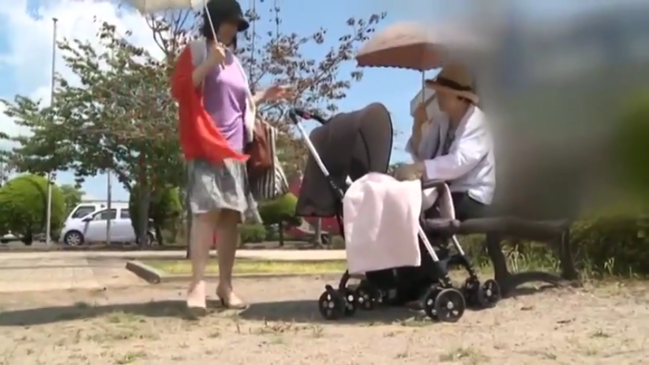 交谈 · 站立 · 自然 · 休闲装 · 远景 · 公园 · 阳光 · 遮阳伞